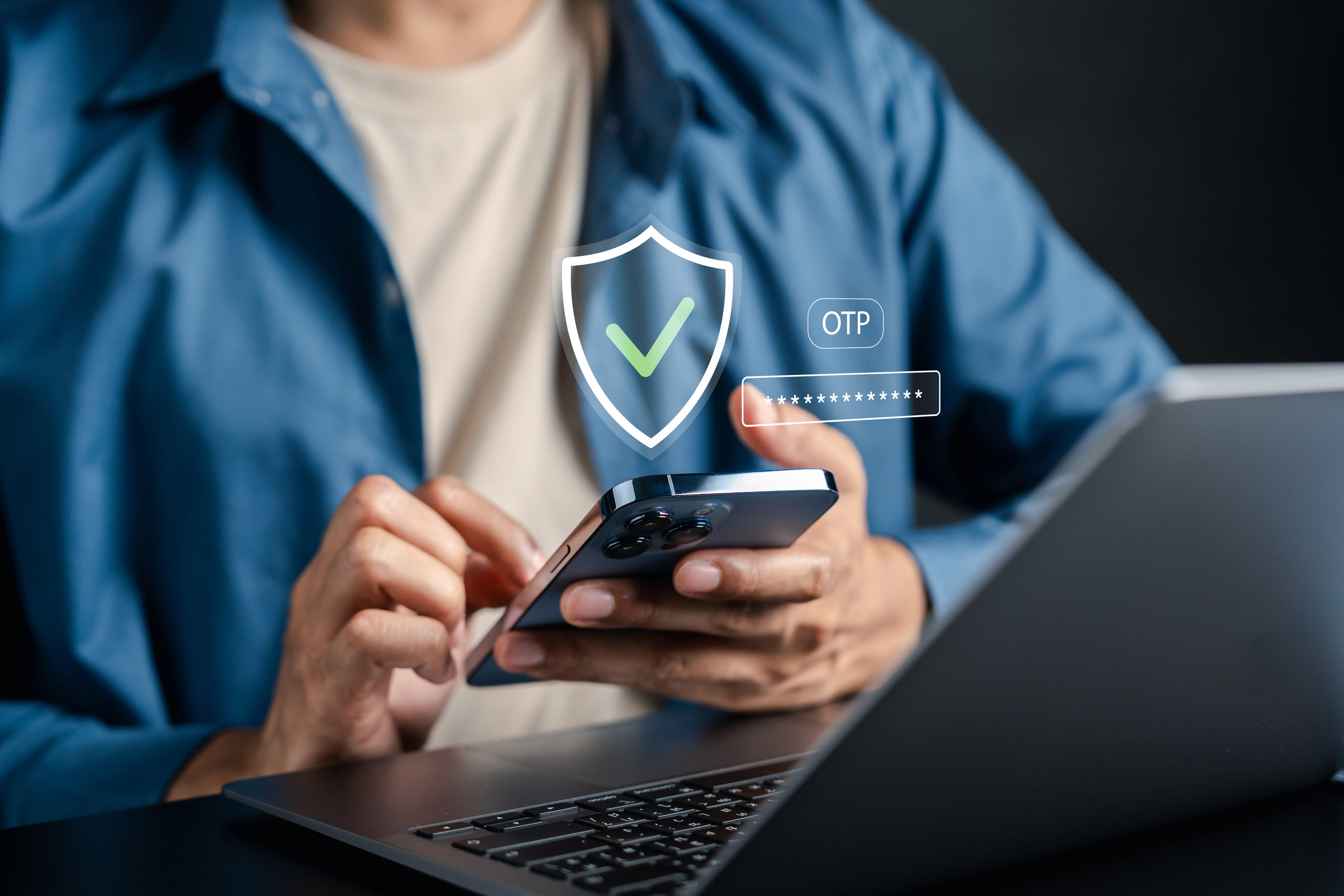 A business professional uses a smartphone with a laptop nearby as digital security icons, including a shield, OTP verification, and password field, represent multi-factor authentication and secure account protection.